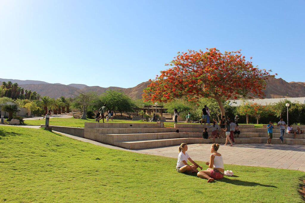 Arava Institute campus landscape, two students seated and talking